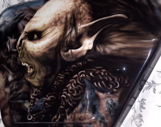 Airbrushed Painting of the lord of the rings, orc soldier on a side panel close up